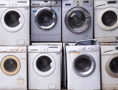 Old, unused washing machines and dryers stacked on top of each other